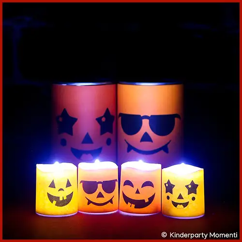 Vier LED-Teelichter mit Halloween-Gesichtern, darunter lachende Kürbisse und ein Gesicht mit Sonnenbrille, in zwei Reihen angeordnet