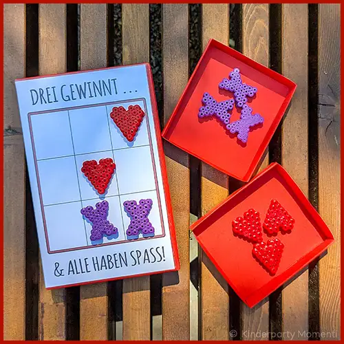 Ein kleines Tic-Tac-Toe-Spiel in einer VHS Hülle liegt auf einer Parkbank.