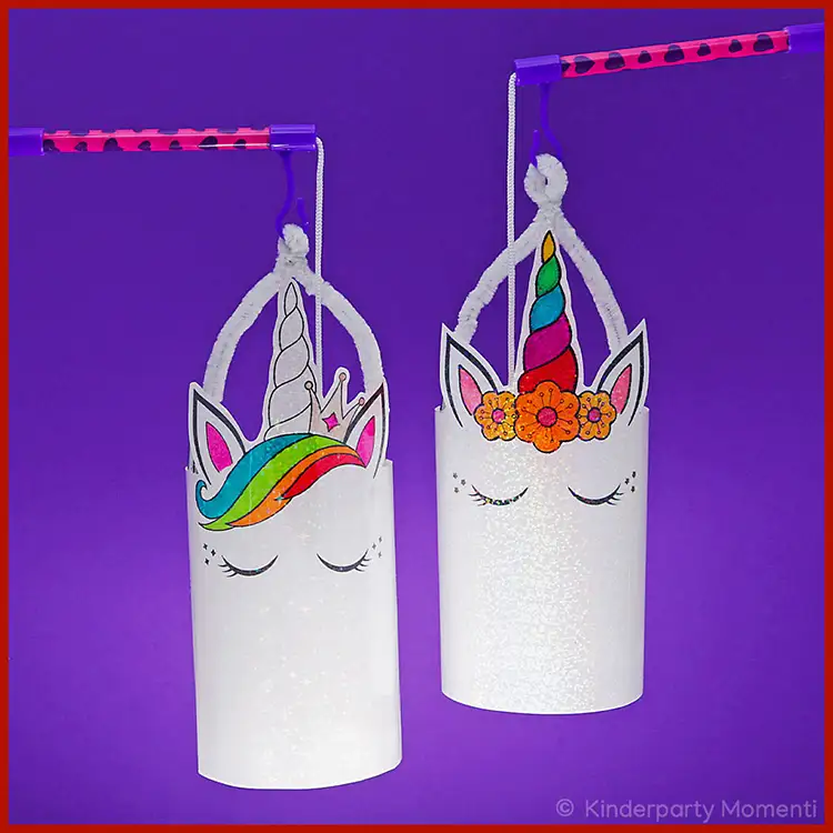 DIY Einhorn Laternen Zwei DIY Einhorn Laternen an Laternenstäben vor einem Lila Hintergrund