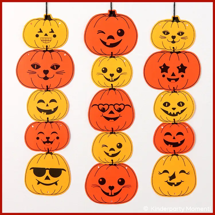 An einer Wand hängen untereinander fröhlichen Kürbissen aus Papier in gelb und orange als Halloween Girlande