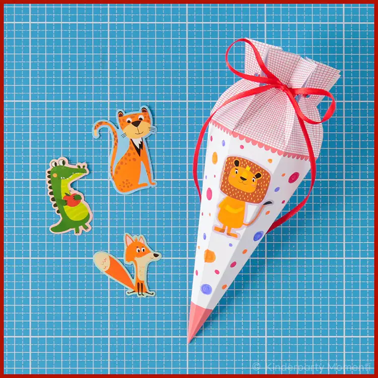 Kleine Schultüten selbst Gestalten mit Stickern Neben einer kleinen selbstgebastelten Schultüte liegen fünf kleine Tier-Sticker.