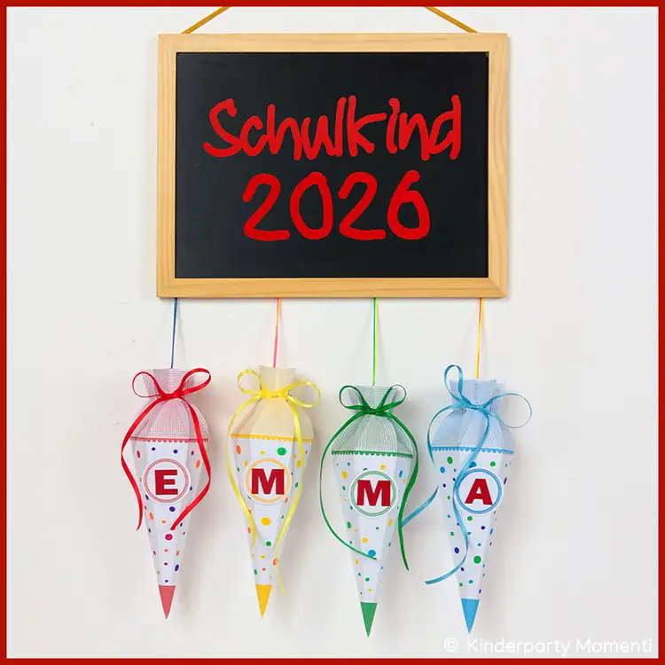 Dekotafel mit Schultüten für Einschulungsfeiern Schultafel mit roter Aufschrift 'Schulkind 2026' und vier bunten Schultüten mit den Buchstaben E, M, M, A